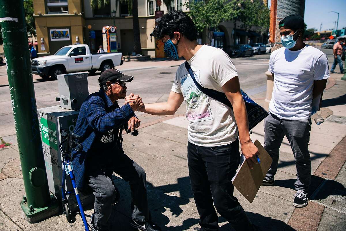 Oakland City Council candidate Richard Santos Raya shakes hand with Hugo Garcia, who has lived in Fruitvale since 1986.