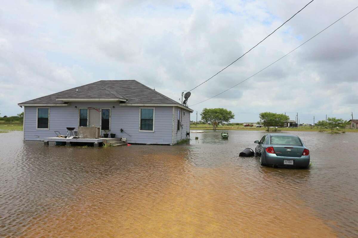 A vehicle sits in more than two feet of floodwater from Hurricane Hanna Monday, July 27, 2020, outside a home on Mescal Street near Laureles, Texas. (Denise Cathey/The Brownsville Herald via AP)