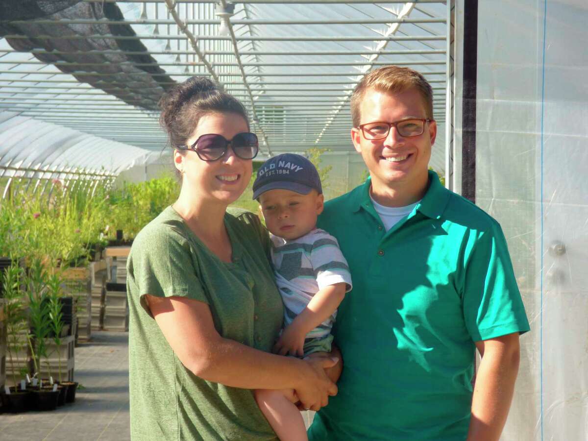 Jennifer and Matt LaMore, co-owners of Black Cap Farm, pose with their son Henry in front of their greenhouse which recently opened in Onekama. (Scott Fraley/News Advocate)