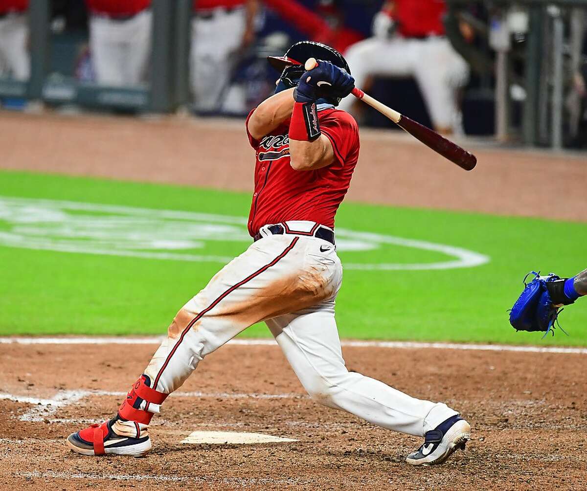 Travis d'Arnaud of the Atlanta Braves hits an eighth inning double with bases loaded against the New York Mets at SunTrust Field on June 31, 2020 in Atlanta, Georgia.