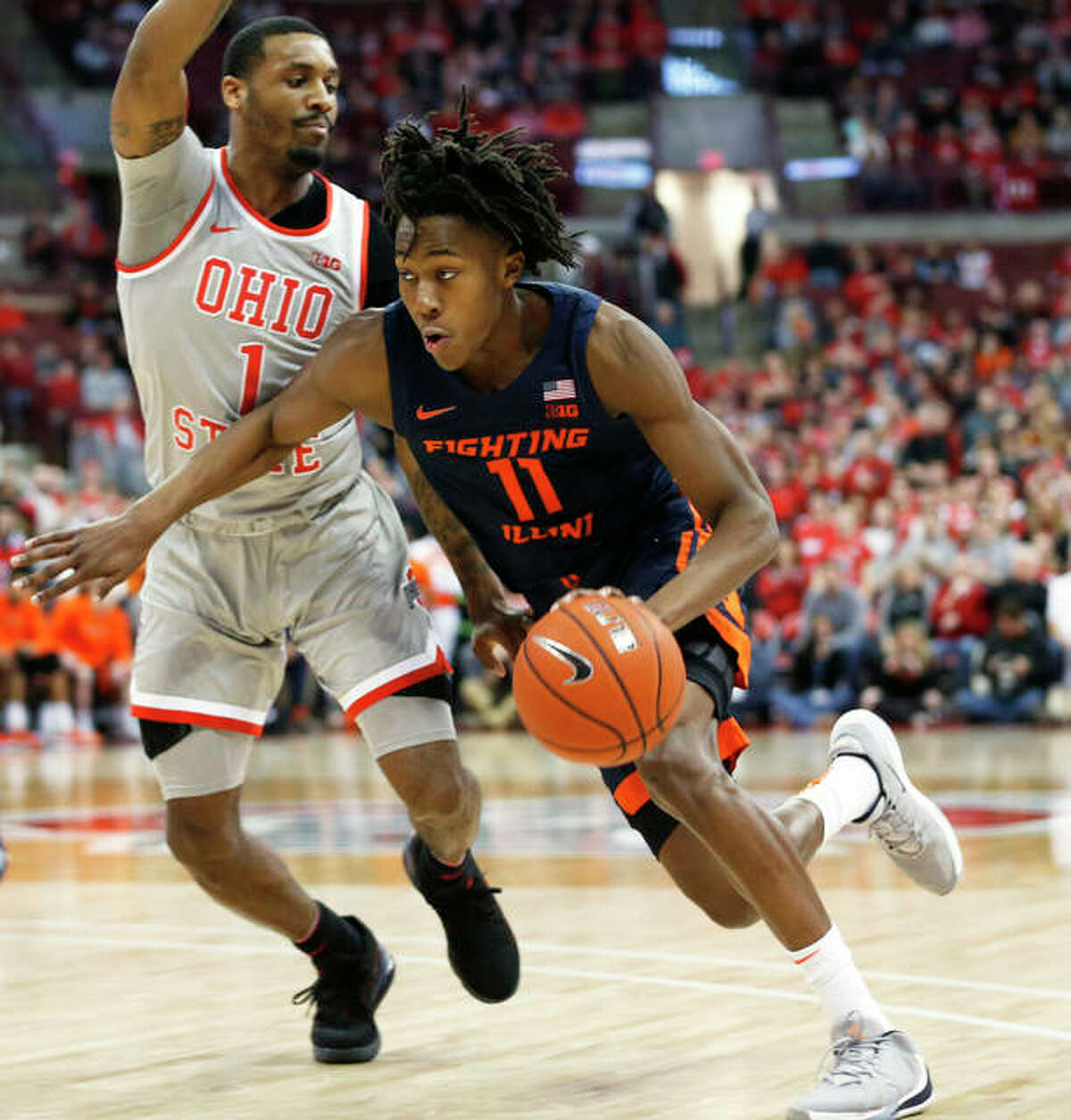 Illinois’ Ayo Dosunmu (right) drives against Ohio State’s Luther Muhammad March 5 in Columbus, Ohio. Dosunmu has announced that he is withdrawing from the NBA Draft and will return to the Illini next season.