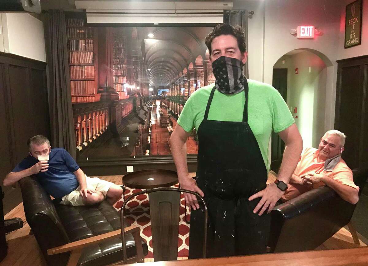 Shane Carty, co-owner and chef at the Trinity Bar in downtown New Haven, oversees a quiet Friday night at the restaurant in front of an enlarged photo of the famous Trinity college library in Dublin, where he’s from.
