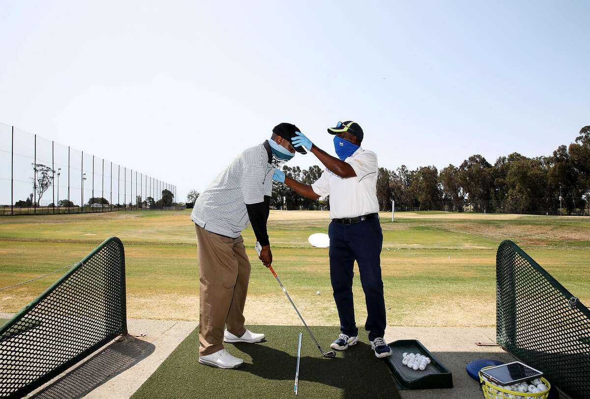 Chad Burr, 38, of San Leandro, left, receives a golf lesson from Winslow "Woody" Woodard, 68, Corica Park Golf Course on Saturday, August 1, 2020, in Alameda, Calif. Woodard is a longtime instructor at Corica Park, where he has been giving lessons for 40 years.
