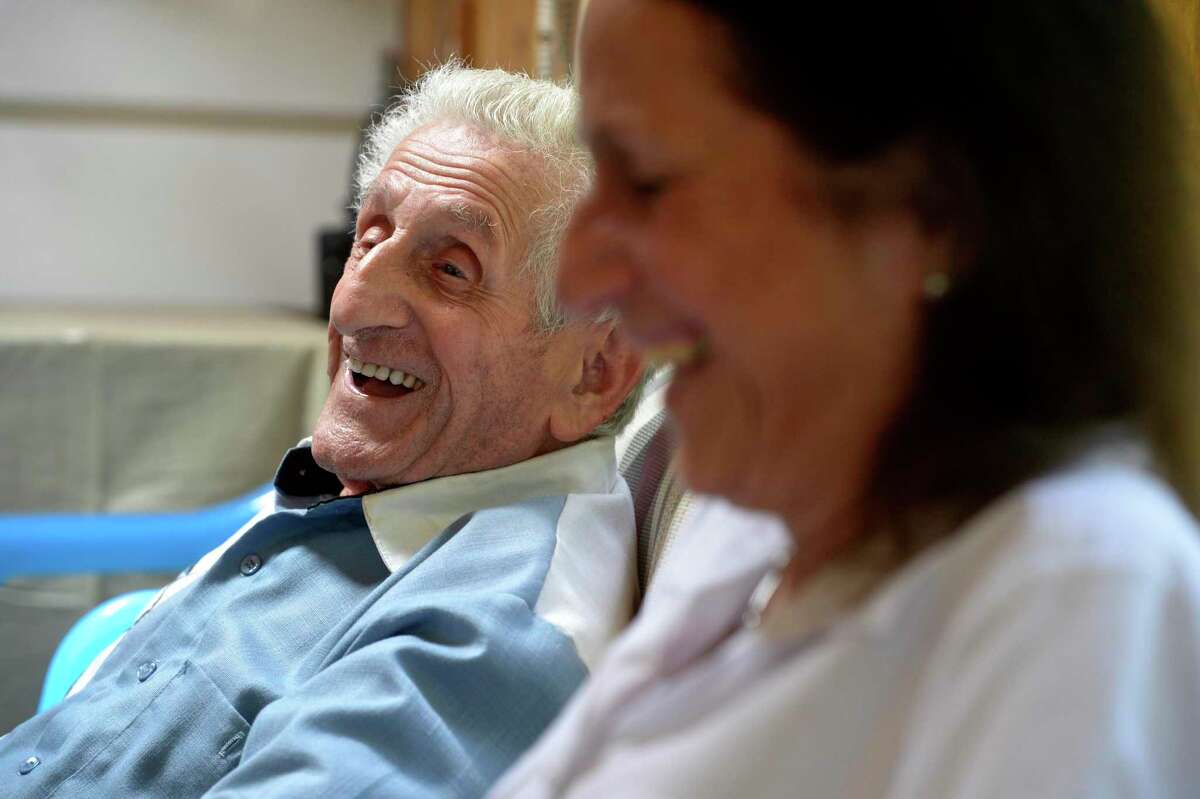 Angelo Testanero, a local musician and arranger who will turn 100 on August 5th, shares a laugh with his daughter Diane Fenwich as he tells a story about burning down a chicken coop when he was young.. Friday, July 31, 2020, in Danbury, Conn.