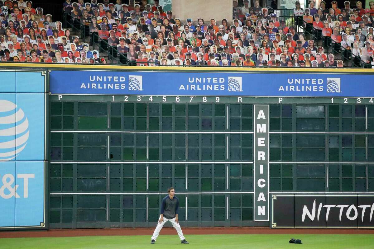 Houston Astros pitcher Zack Greinke shags balls in the outfield with the Astros fan cutouts before the start of the Houston Astros Opening Day at Minute Maid Park, Friday, July 24.