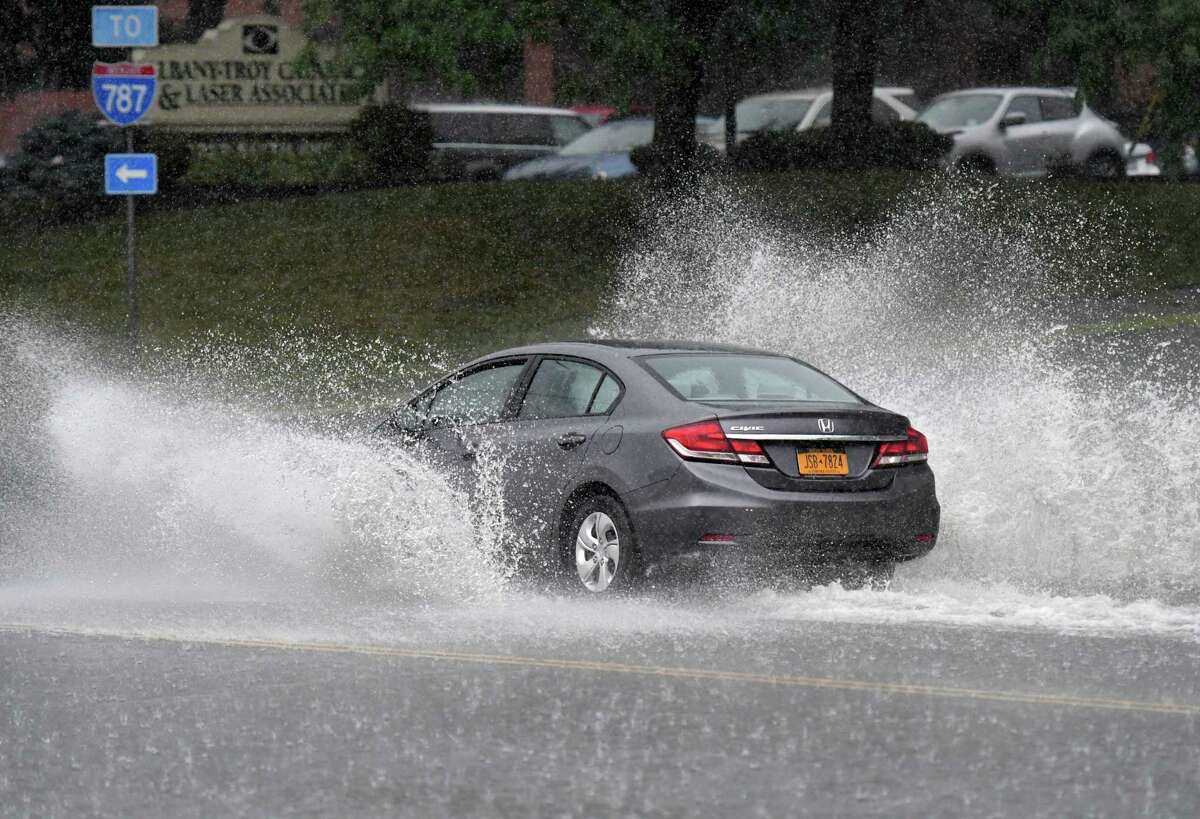 Rainwater is thrown from cars on Sixth Avenue as Tropical Storm Isaias pushes through the Capital Region on Tuesday, Aug. 4, 2020, in Troy, N.Y.