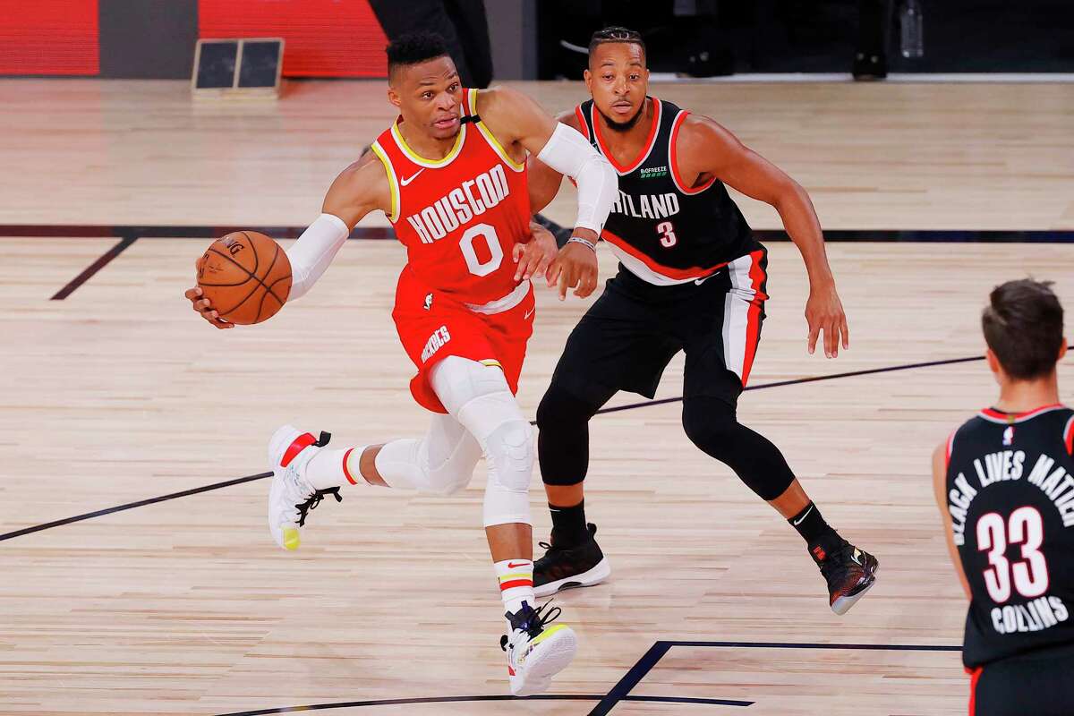 Russell Westbrook, left, of the Houston Rockets drives to the basket against CJ McCollum, right, of the Portland Trail Blazers during the first half of an NBA basketball game Tuesday, Aug. 4, 2020, in Lake Buena Vista, Fla. (Kevin C. Cox/Pool Photo via AP)