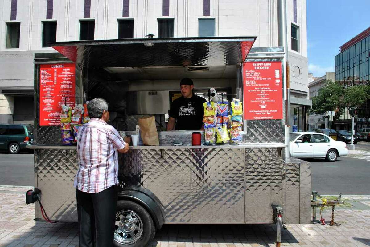 Joe Marzan tends the Snappy Dogs food cart outside the State Courthouse on the corner of Fairfield Avenue and Main Street in Bridgeport. Marzan runs the cart with his mother Janet Marzan.
