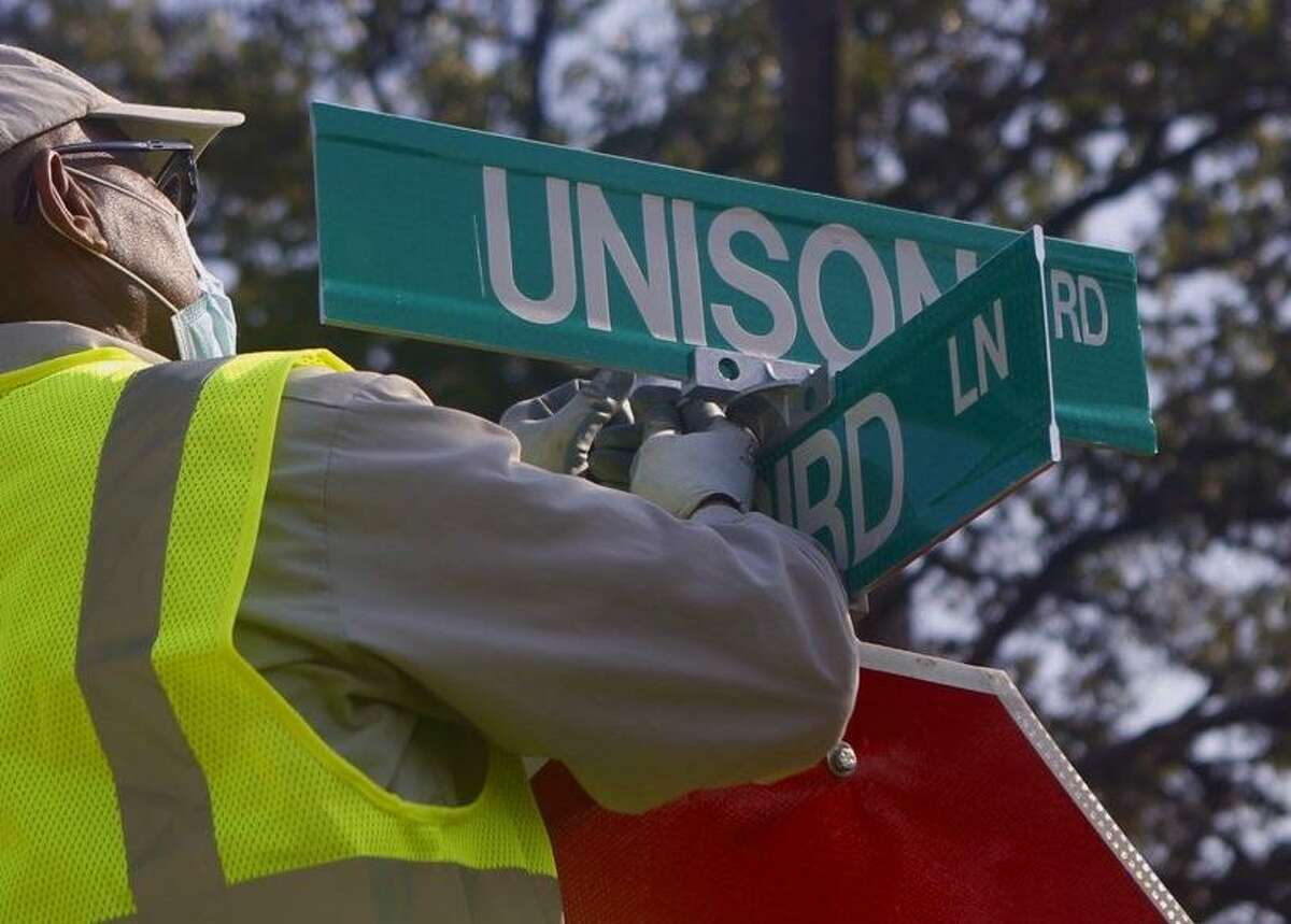 Workers install new signs for Unison Road on August 5, 2020. The original Robert E. Lee road signs were taken down soon after the announcement to change the name of the road. Its unclear who took those signs down as the county sign shop department said they were not responsible.