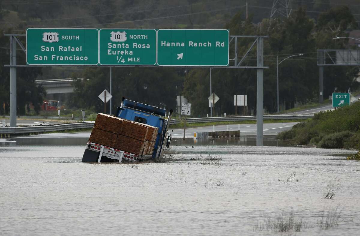 A big rig hauling lumber is trapped in flood water on westbound Highway 37 after water from heavy rainstorms flooded the roadway for the second time in a month closing the segment between Highway 101 and Atherton Avenue in Novato, Calif. on Wednesday, Feb. 27, 2019.