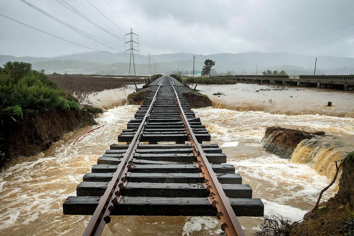 Railroad tracks hang suspended above flood waters following a levee break along highway 37 near Novato, Calif., on Thursday, Feb. 14, 2019. Water from Novato Creek was sent rushing beneath the tracks after the ground below gave way.