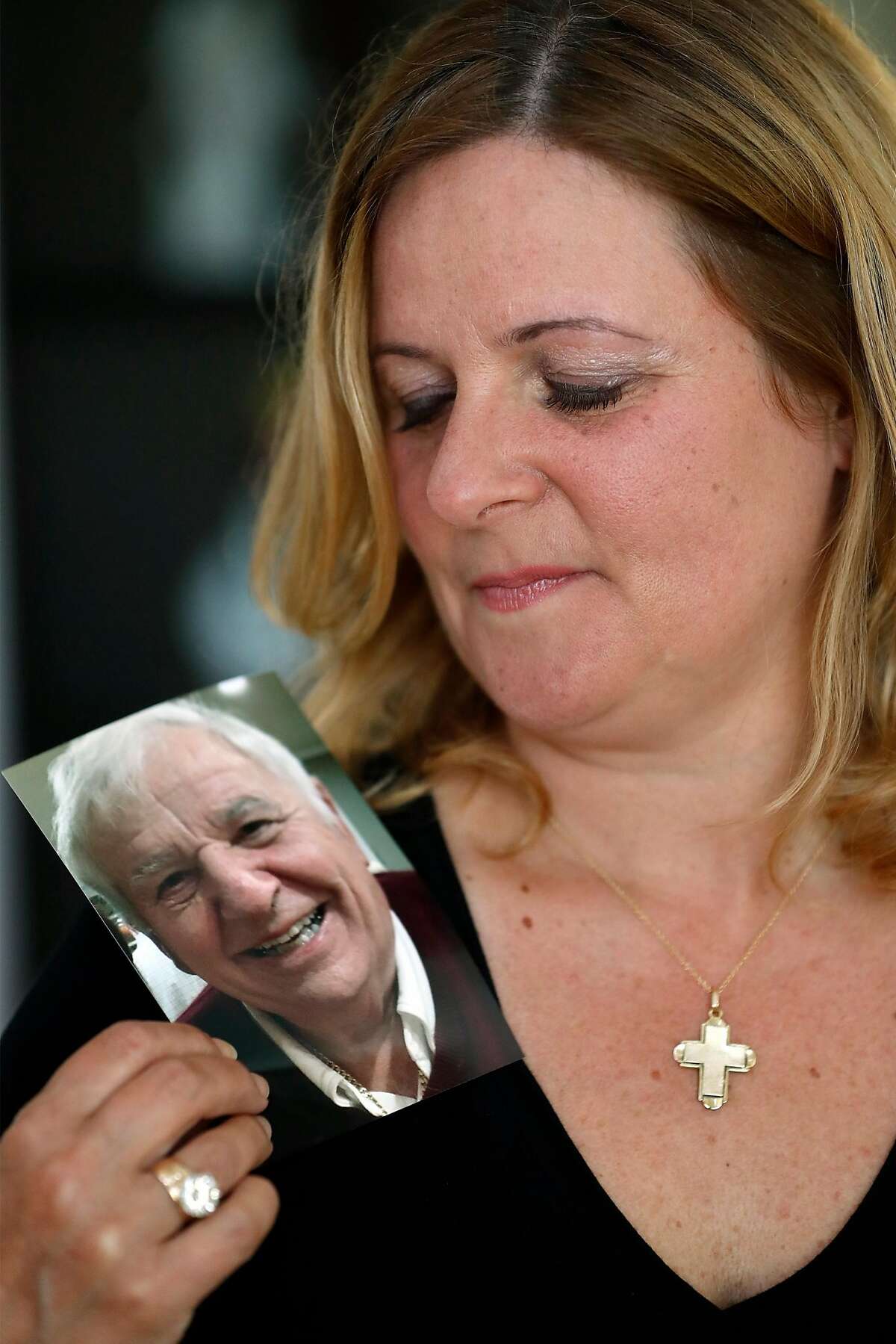Tina Gullotta poses with a photo of her 87-year-old father, Harry Misthos in San Bruno, Calif., on Thursday, June 18, 2020. Misthos died from coronavirus earlier this year.