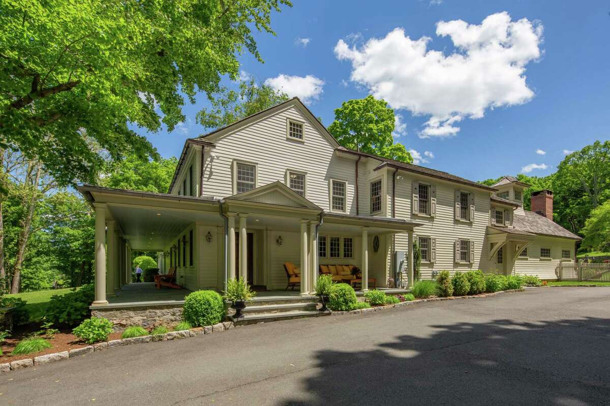 The stone, stucco, and clapboard colonial house at 67 Ridgefield Road sits on a corner lot only steps from Wilton Center.
