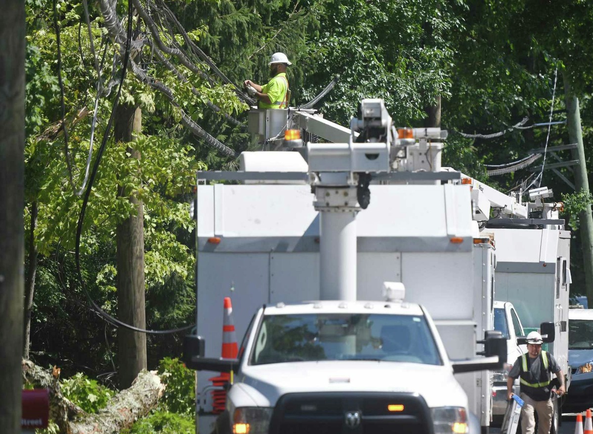 Crews repair power lines downed from tropical storm Isaias in Greenwich, Conn. Wednesday, Aug. 5, 2020. Tuesday's storm knocked down trees and powerlines throughout the state and power remains out in thousands of homes.