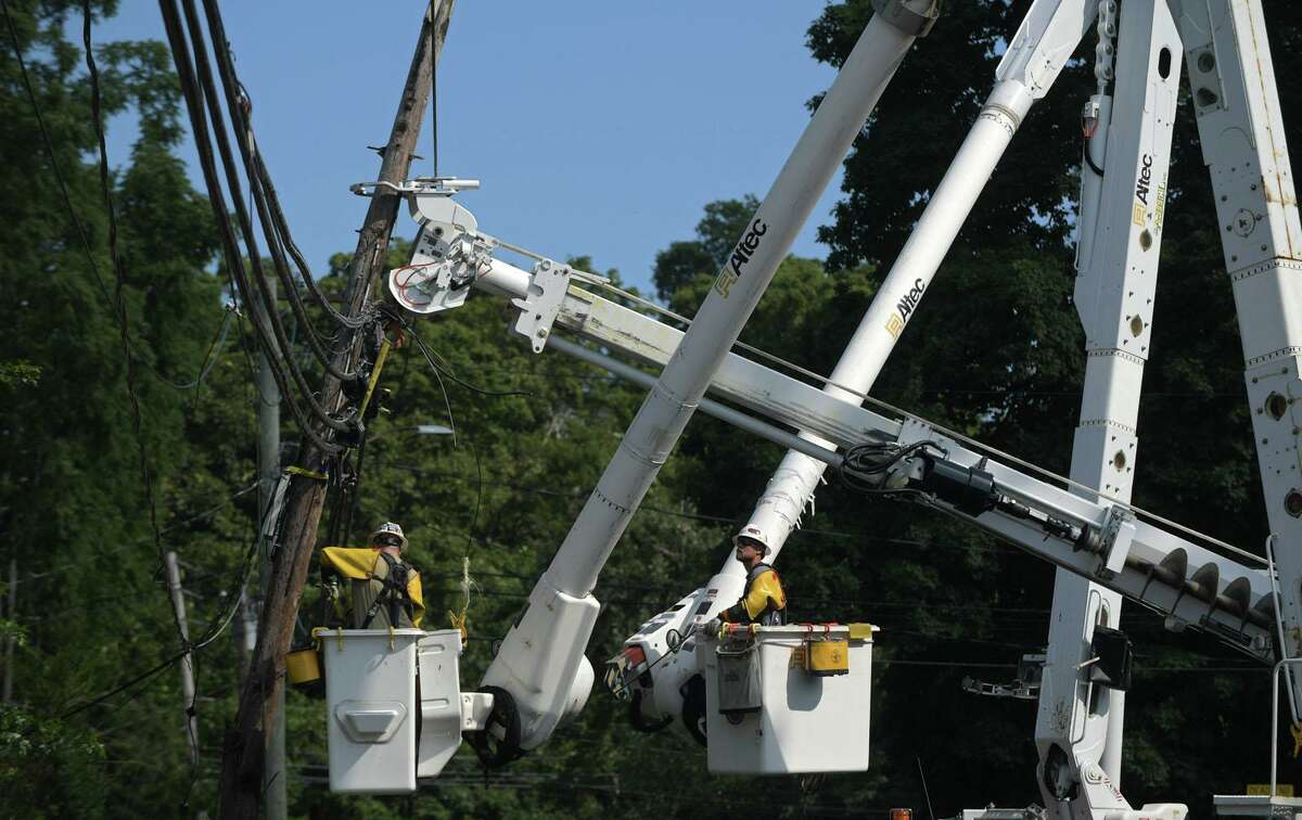 Eversource workers repair damage to utility lines following damage wrought by tropical storm Isaias Wednesday, August 5, 2020, which brought down trees with wind gusts up to 70 miles per hour in Norwalk, Conn.
