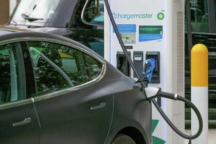 An electronic automobile charges at a BP station in London.