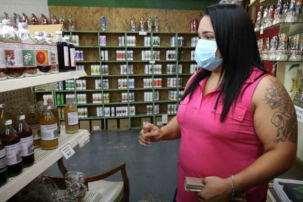 Megan Fernandez, 32, of Poteet, browses items at Papa Jim’s Botanica. More and more people are turning to botanicas for help in coping with the COVID-19 epidemic, such as getting or keeping a job to herbal teas for breathing problems.