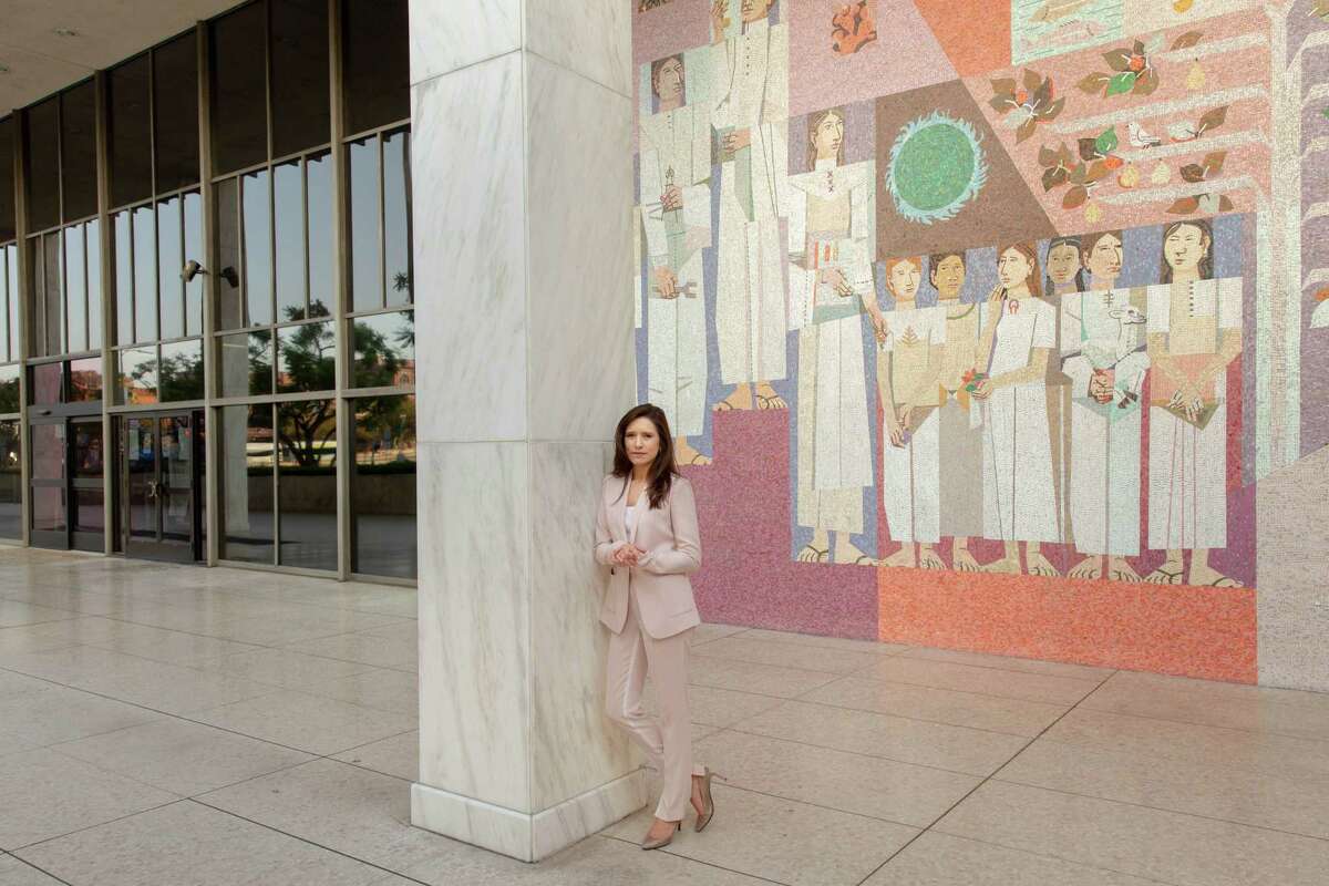 Jessica Denson, the Trump campaign's former Hispanic outreach director, stands in front of a mural by Richard Haines titled "Celebration of our Homeland" at the Federal Building in downtown Los Angeles.
