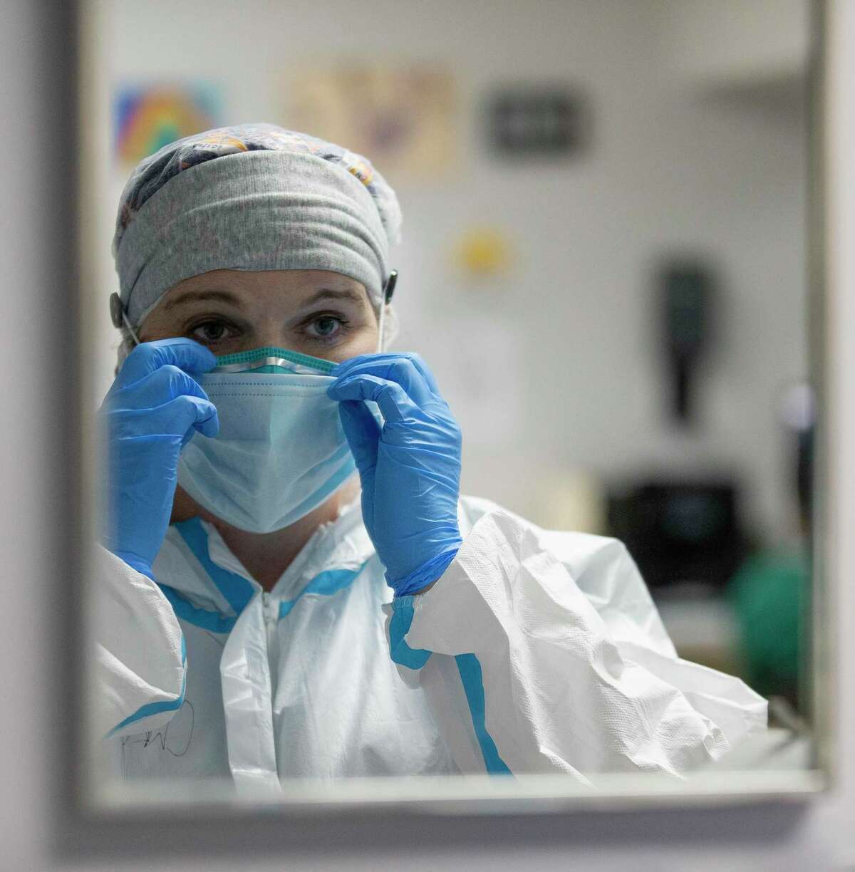 Nurse Christina Mathers adjusts her mask before checking on patients at United Memorial Medical Center.