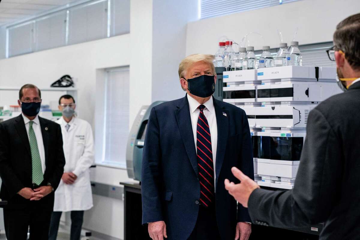 President Donald Trump, wearing a face mask, tours the Bioprocess Innovation Center at Fujifilm Diosynth Biotechnologies in Morrisville, N.C., on Monday, July 27, 2020. President Trump, on July 29, vowed to protect suburbanites from low-income housing being built in their neighborhoods, making an appeal to white suburban voters by trying to stir up racist fears about affordable housing and the people who live there.