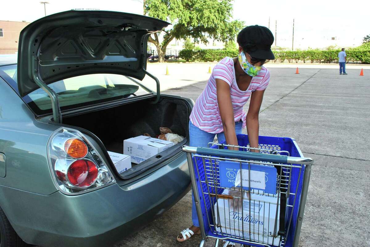 Mobile Food Fair at Northwest Assistance Ministries on July 18, 2020. Volunteers directed traffic, sorted groceries, made grocery bags, and loaded food into vehicles.