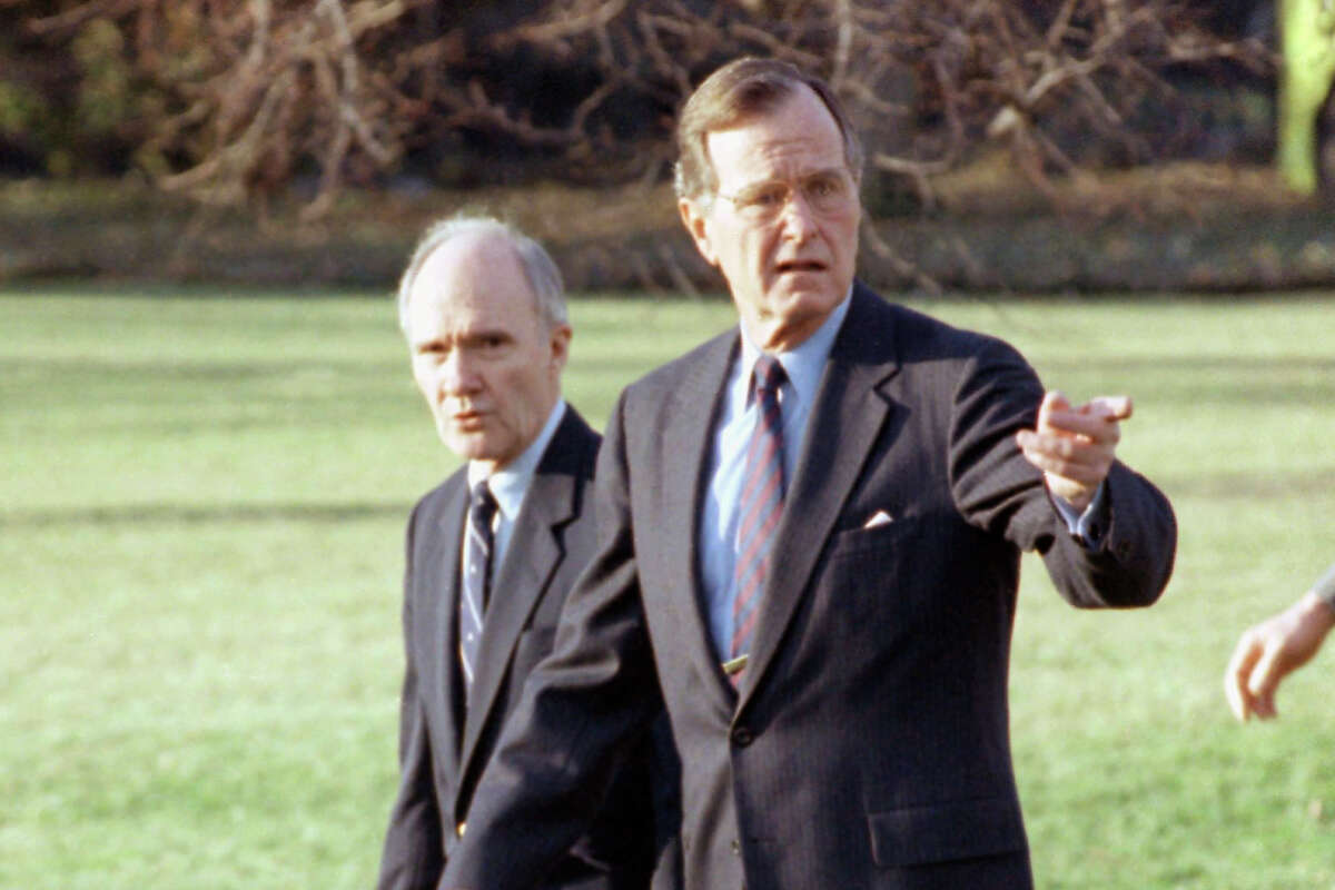 FILE - In this Feb. 6, 1990 file photo, President George H. W. Bush gestures as he and National Security Adviser Brent Scowcroft walk to the presidential helicopter on the South Lawn of the White House in Washington. (AP Photo/Barry Thumma)
