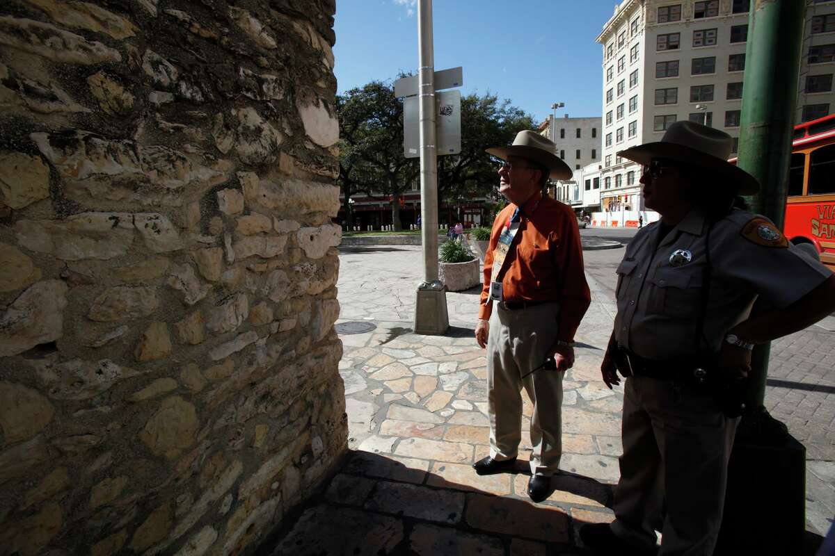 Alamo Director David Stewart, left, and Alamo Ranger Elizabeth Arce examine a wall of the Alamo that was vandalized with graffiti in early 2009.