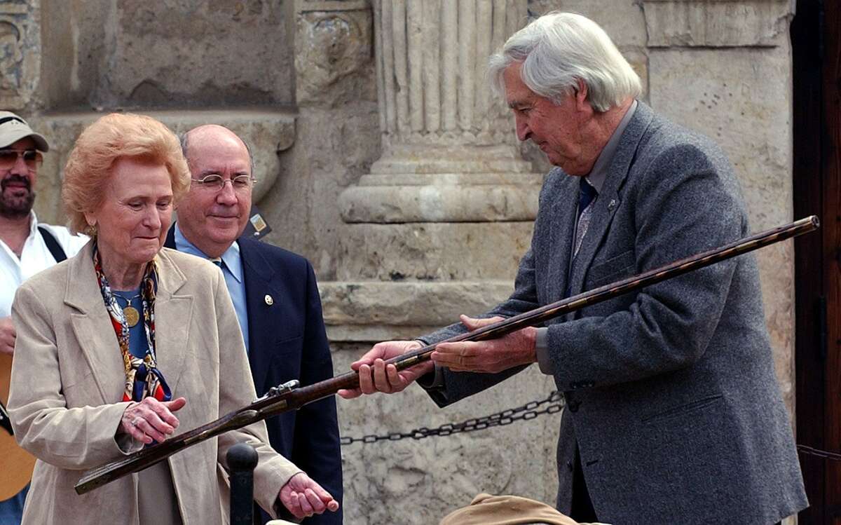 Actor Fess Parker, who portrayed David Crockett in a Walt Disney television series (right) donates a 180-year-old long rifle to the Daughters of the Republic of Texas. Receiving the rifle is DRT Alamo Committee chairwoman Madge Roberts (left) and Alamo Director David Stewart.