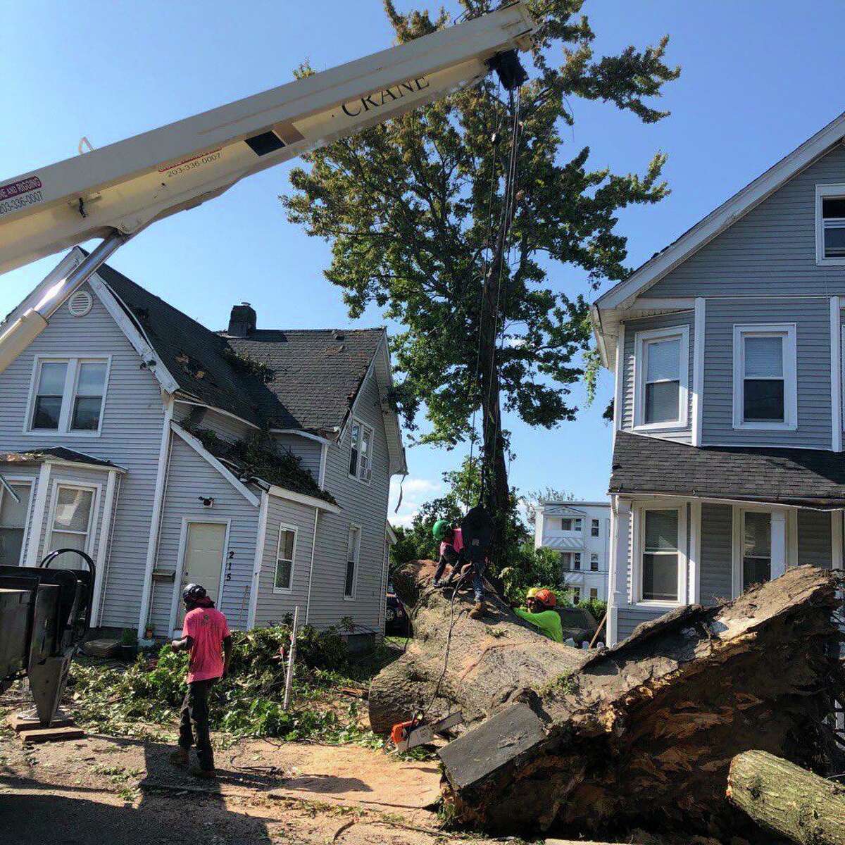 A tree down between homes on Beardsley Street in Bridgeport, Conn., on Saturday, Aug. 8, 2020.