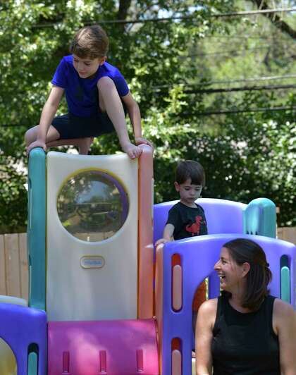 Lara August enjoys a moment with her children, Truman, top, and Leo. The family has decided to hire a nanny so the children can stay home and do remote learning during the pandemic.