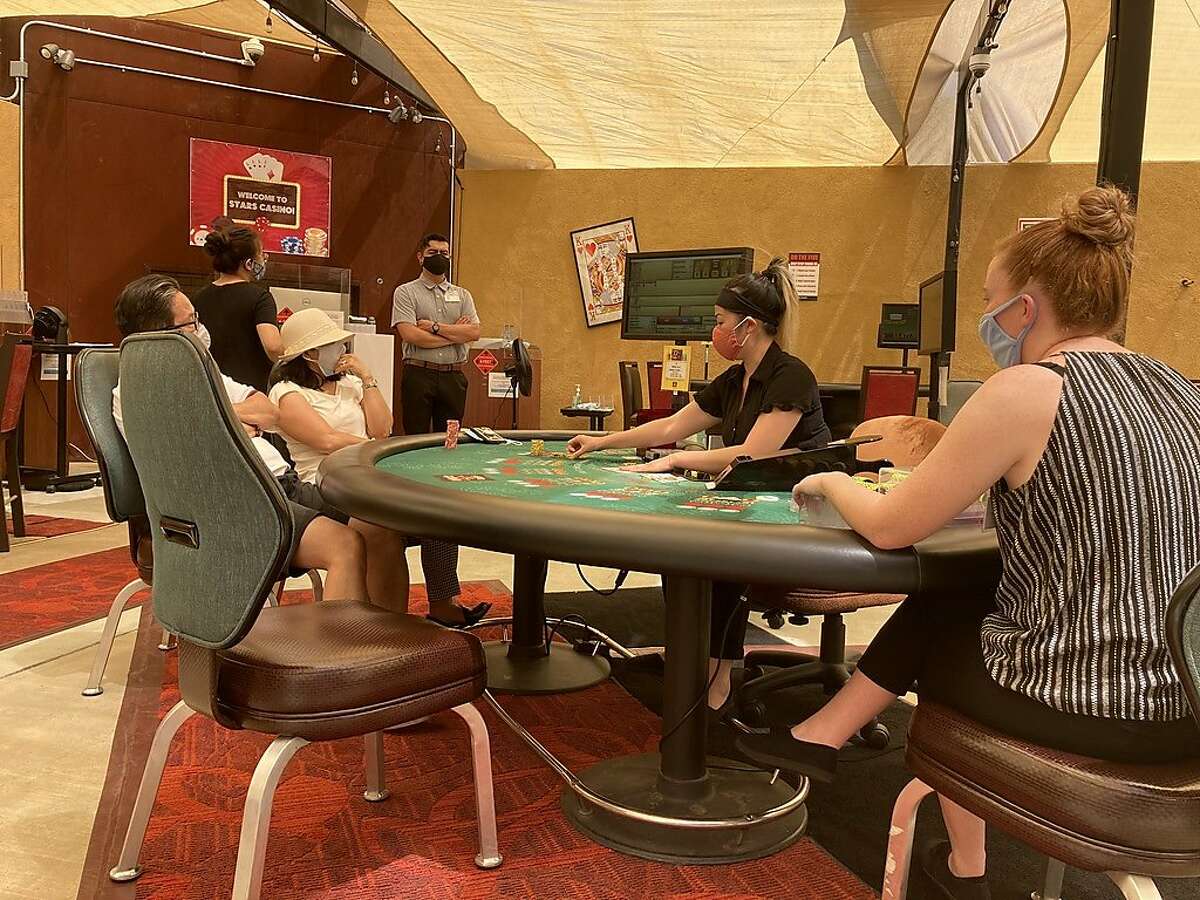 With watchful floor assistant assuring proper distancing, gamblers play�baccarat Sunday afternoon at Tracy's Stars Casino -- the first to open an outdoor card room in the state.