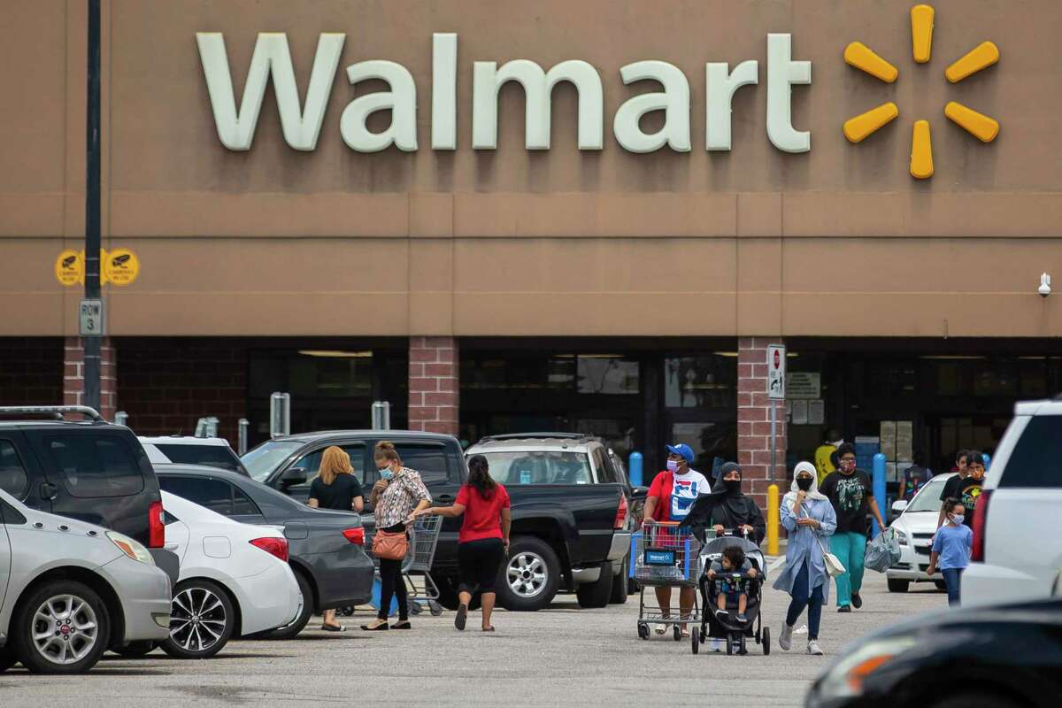 Customers walk through the parking lot of a Walmart on Sunday, Aug. 9, 2020, in southwest Houston.