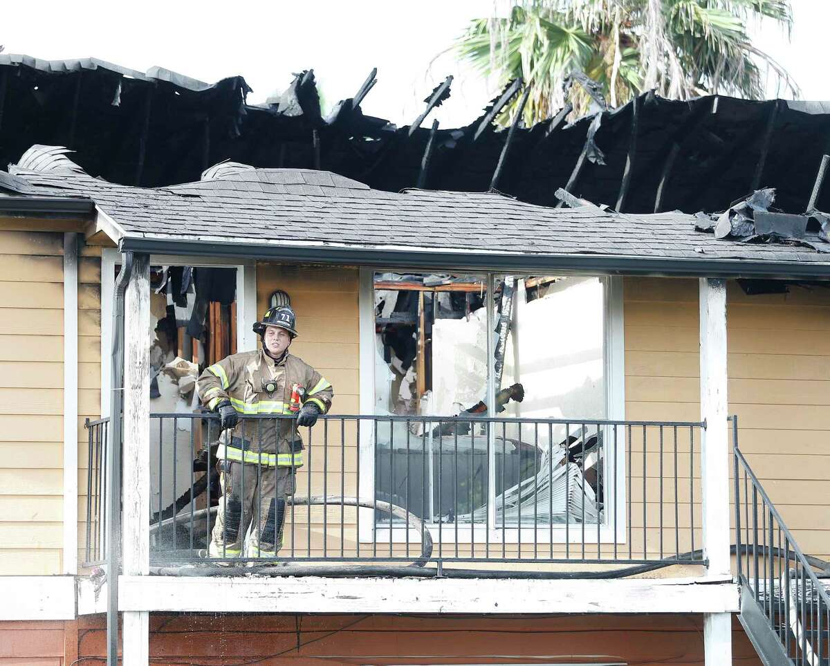 A Spring Firefighter prods the ceiling of one of nine apartment units at Palms At Cypress Station damaged by a two-alarm fire, Sunday, August 9, 2020, in Houston. Ponderosa Fire Chief Fred Windisch said there were no injuries reported and there was "extensive damage" to nine units, seven units were occupied. The complex has no fire hydrants on the premise, which hindered firefighters from multiple agencies.