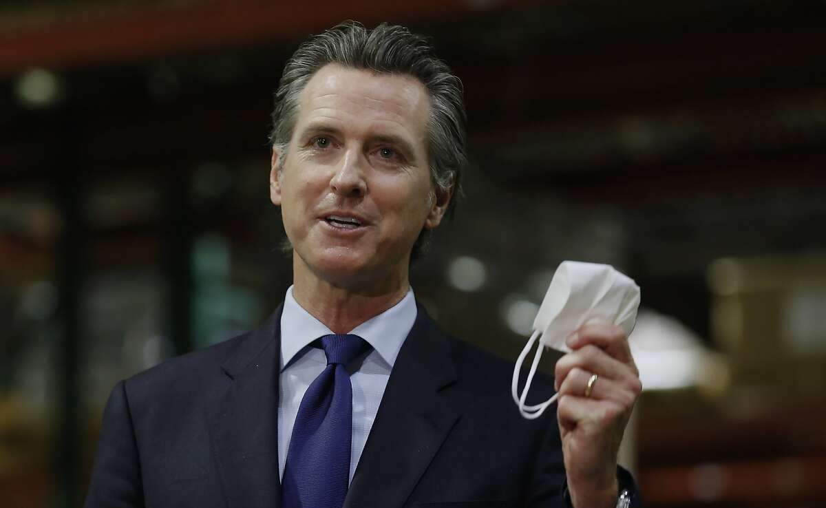 FILE - California Gov. Gavin Newsom displays a face mask as he urges people to wear them to fight the spread of the coronavirus during a news conference in Rancho Cordova, Calif., Friday, June 26, 2020. Gov. Newsom is cautiously optimistic that California is getting a grip on a resurgence of the coronavirus. But he warned Monday, Aug. 3, 2020, that the state is a long way from reopening some of the businesses it shuttered for a second time last month when new cases, hospitalizations, and deaths began surging. The seven-day average and rate of positive tests are both down, as are hospitalizations and intensive care cases. (AP Photo/Rich Pedroncelli, Pool, File)