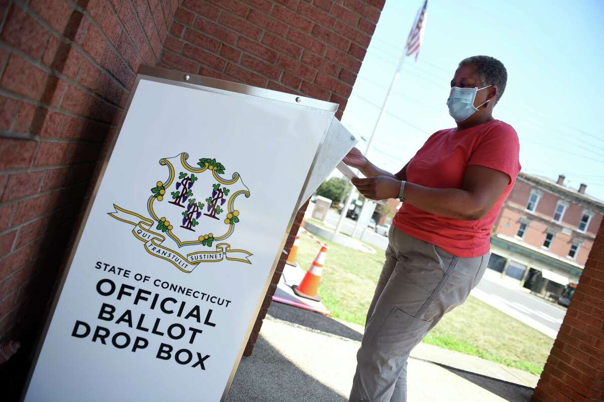 Karyn Stokes drops off her absentee ballot at an Official Ballot Drop Box in front of West Haven City Hall on August 10, 2020.