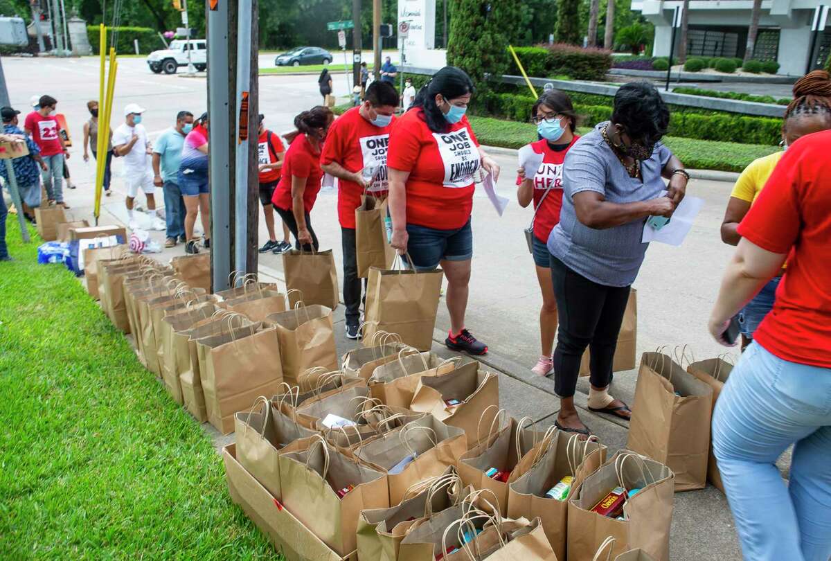 Food is distributed to unemployed people by the organization UNITE Here, a union that represents hospitality workers, along Memorial Drive on Tuesday, Aug. 11, 2020, outside of Senator John Cornyn's office in Houston. The demonstration involved a food distribution for unemployed hospitality workers who have watched their $600 unemployment benefits expire.