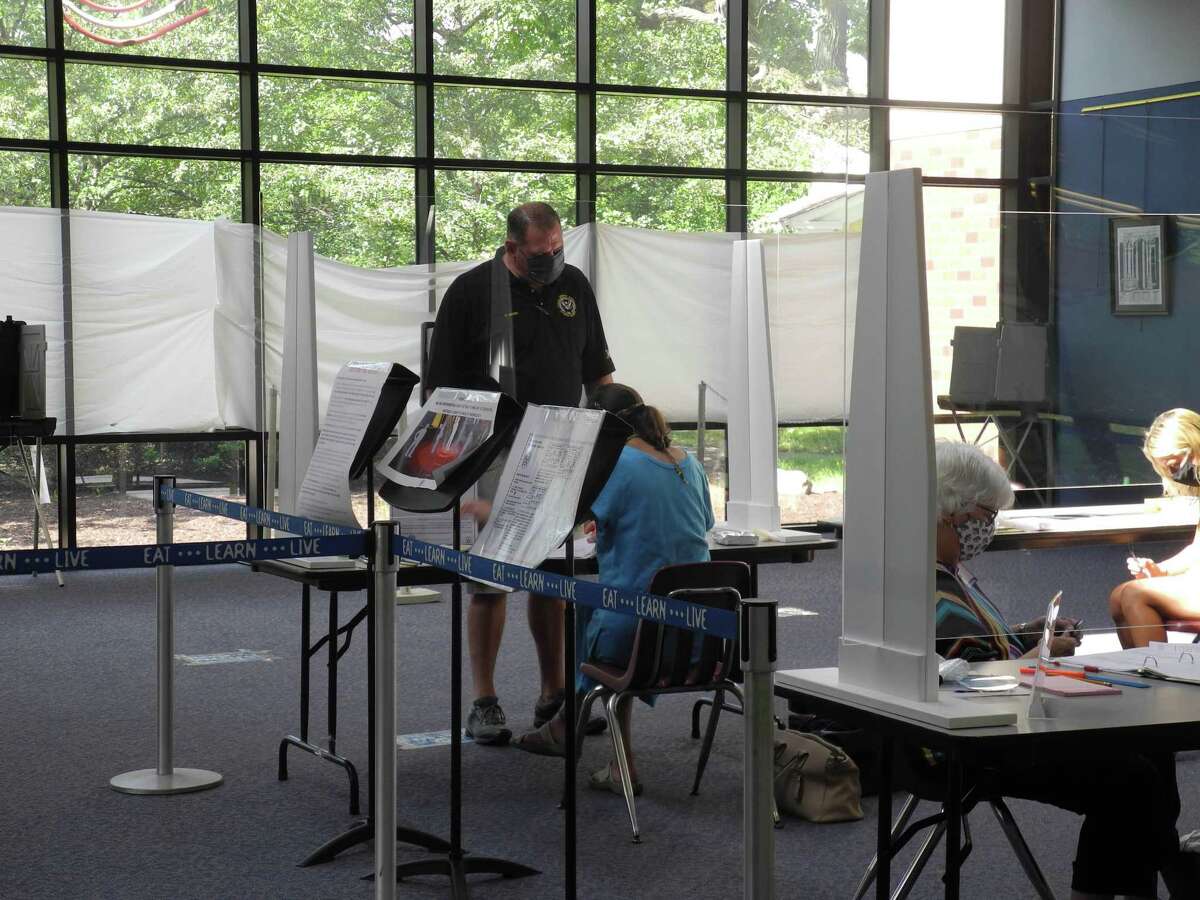 A voter checks in at the polling place at Wilton High School on Aug. 11.