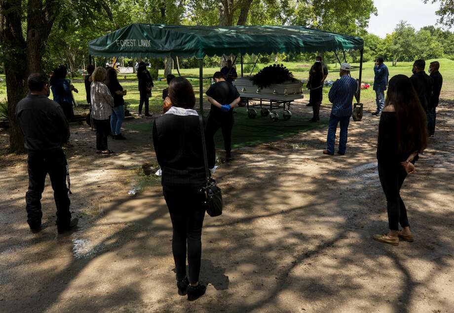 Family members stand socially distant while attending the funeral of Trancito Rangel Diaz, 46, a construction worker who died of COVID-19, at Forest Lawn Cemetery on Aug. 4 in Houston. Photo: Godofredo A. Vásquez/Staff Photographer / ? 2020 Houston Chronicle