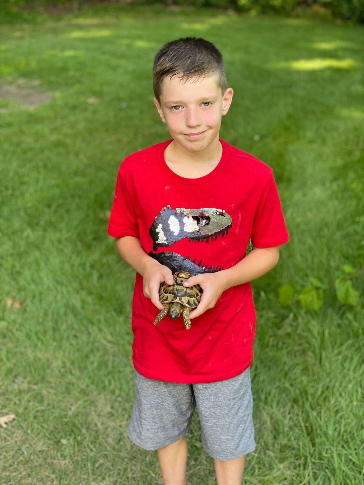 Rex Oliveira with his pet tortoise Speedy, who is back home after a month-long escape. A heart painted on Speedy's back helped Rex and his family connect with the people who found him.