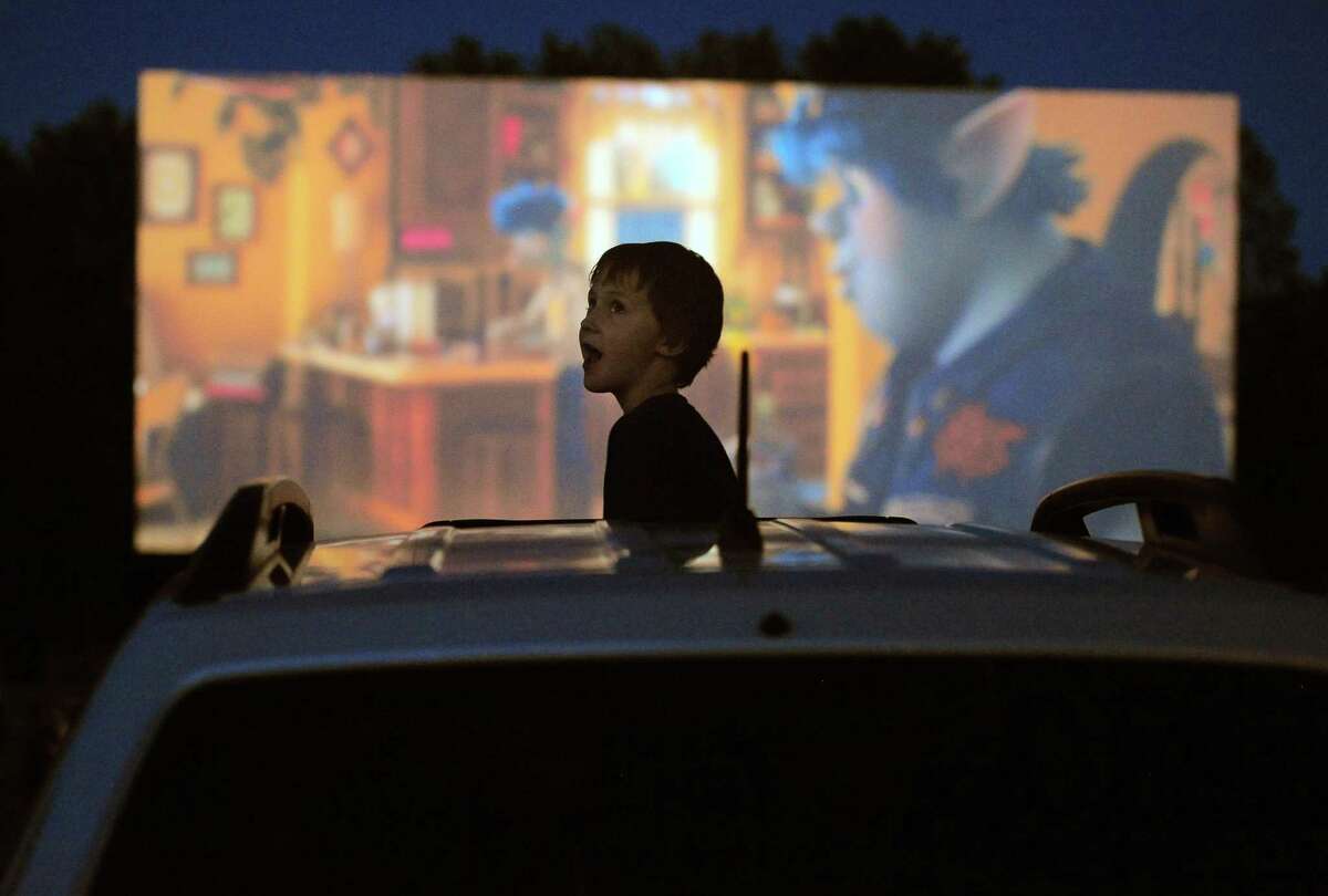 Patron William Rhines, 7, of Conventry enjoys the Disney movie “Onward” at Mansfield Drive-In Movie Theater in Mansfield in late May.