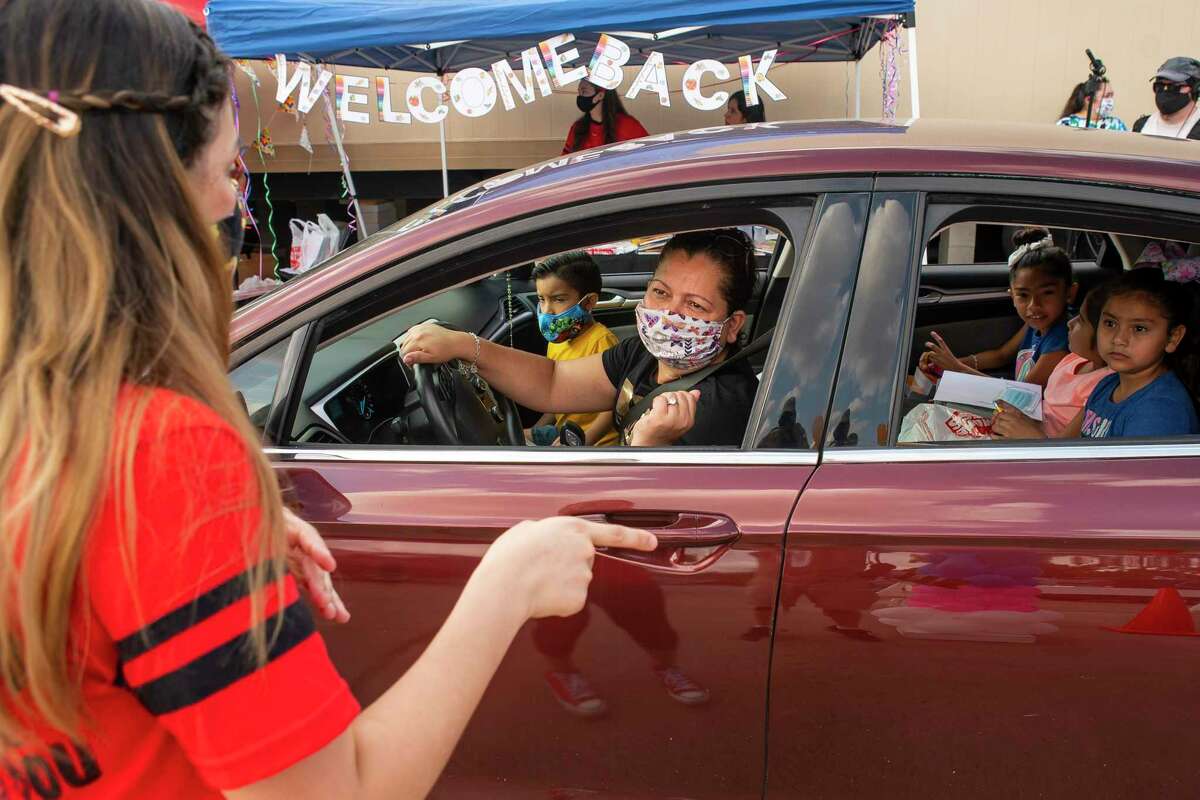 A family in Houston participates in a drive-thru meet-the-teacher event earlier this month. As the school year approaches and COVID-19 continues to spread, school leaders need more time, flexibility, clarity and resources to safely reopen.
