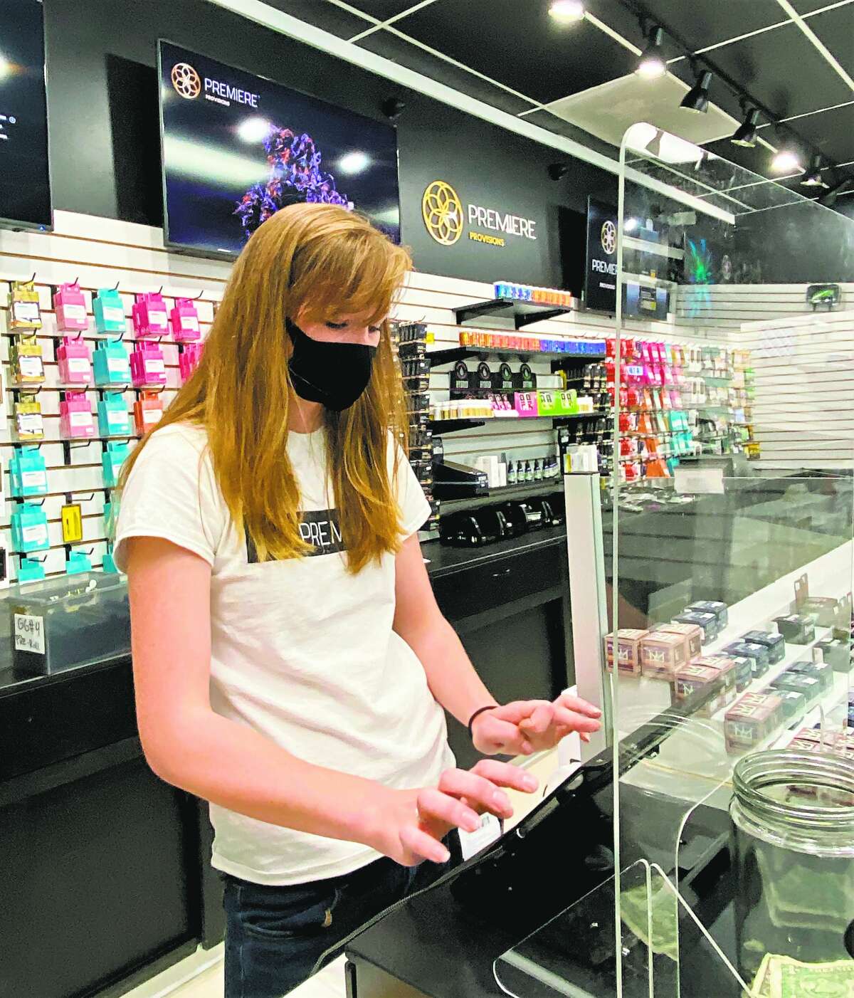Premiere Provisions Budtender MacKenna Myers works at the register, while practicing social distancing and mask wearing due to the current coronavirus pandemic.