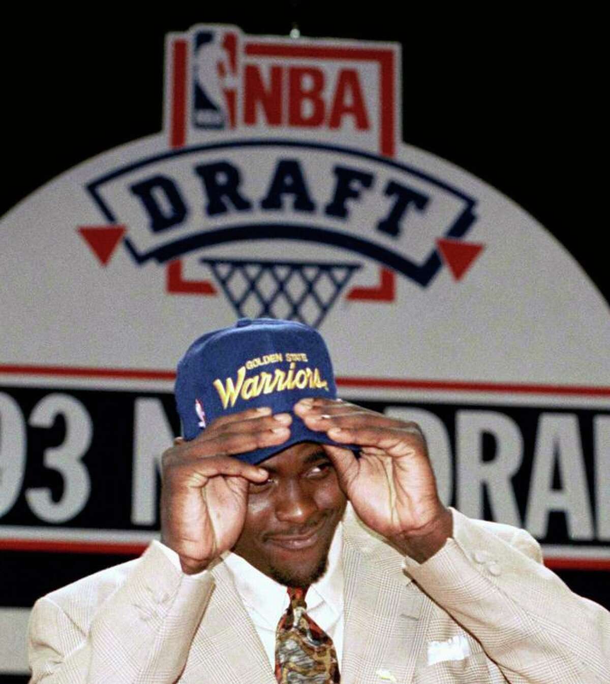 Michigans Chris Webber puts on a Golden State Warriors hat after Webber was traded to Golden State during the NBA draft at the Palace, Wednesday, June 30, 1993, Auburn Hills, Mich. Webber was the first selection in the draft by the Orlando Magic, then he was traded to Golden State when the Warriors selected, Anfernee Hardaway as the third pick. (AP Photo/Lennox Mclendon)
