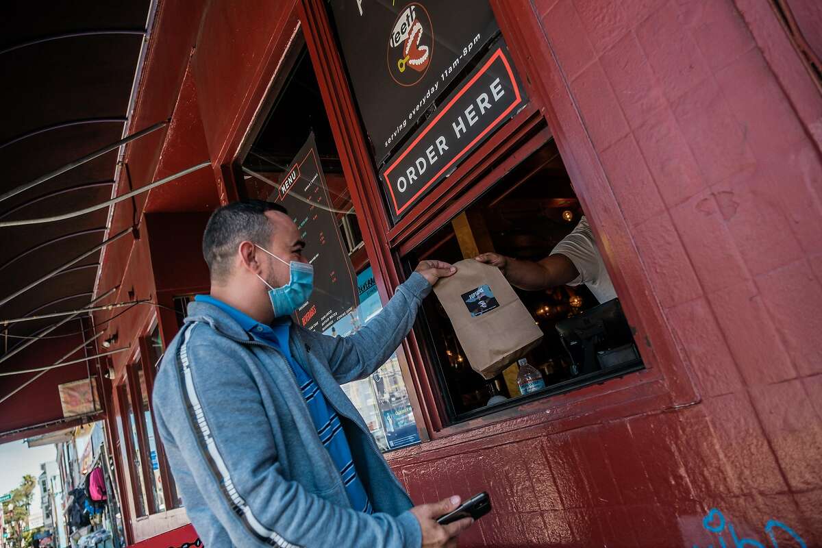 Claudio Mamar a driver for Door Dash picks up his delivery from Popsons Burgers in San Francisco on Tuesday, June 30, 2020.