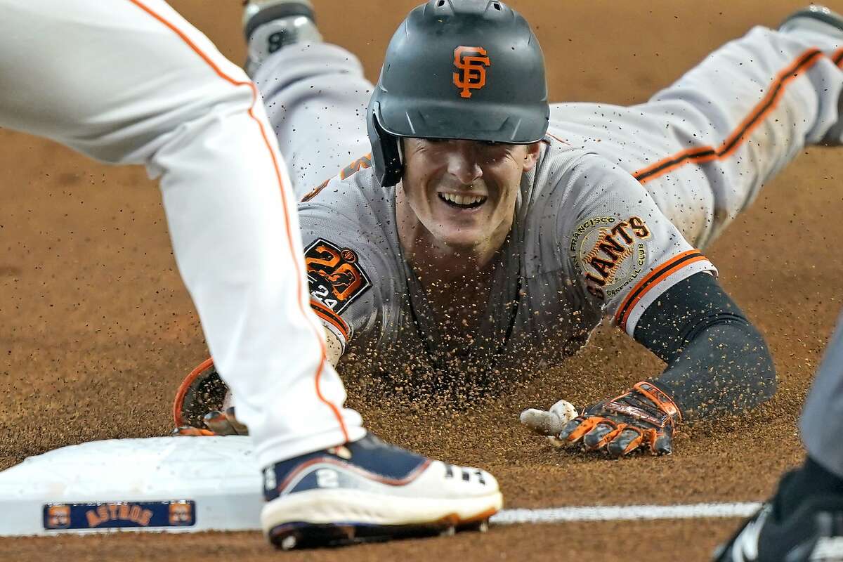 San Francisco Giants' Mike Yastrzemski dives toward third base after hitting a triple against the Houston Astros during the first inning of a baseball game Wednesday, Aug. 12, 2020, in Houston. (AP Photo/David J. Phillip)