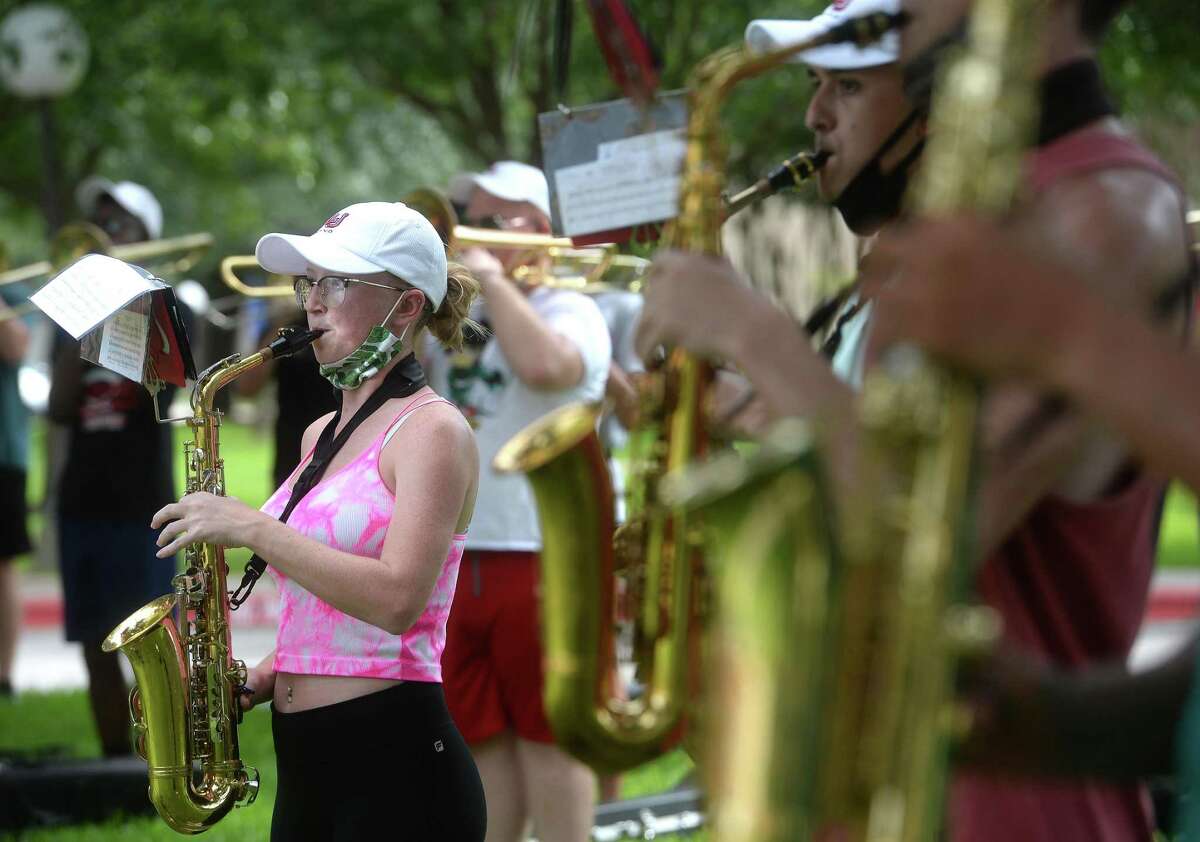 Members of Lamar University's marching band, including saxophonist Kristal Deville, rehearse beneath the shade of trees as they begin to prepare for the hopeful start of their performance season. Photo taken Wednesday, August 12, 2020 Kim Brent/The Enterprise