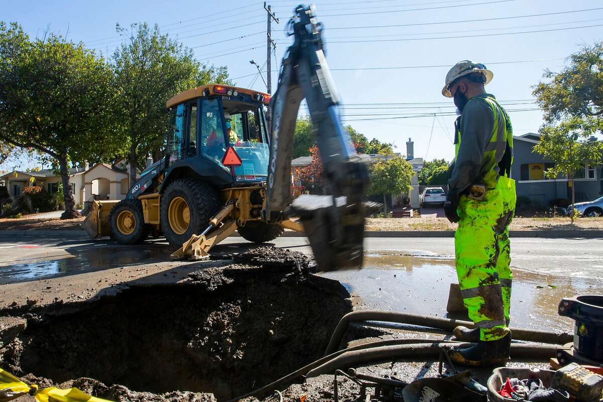 A team of six East Bay Mud employees help to brace one of a dozen main water line breaks in West Berkley on the morning of August 13, 2020.