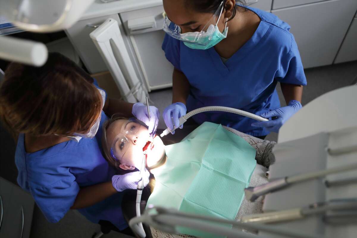 A dentist examines a patient's teeth and gums. Gum disease has been linked to severe cases of COVID-19.