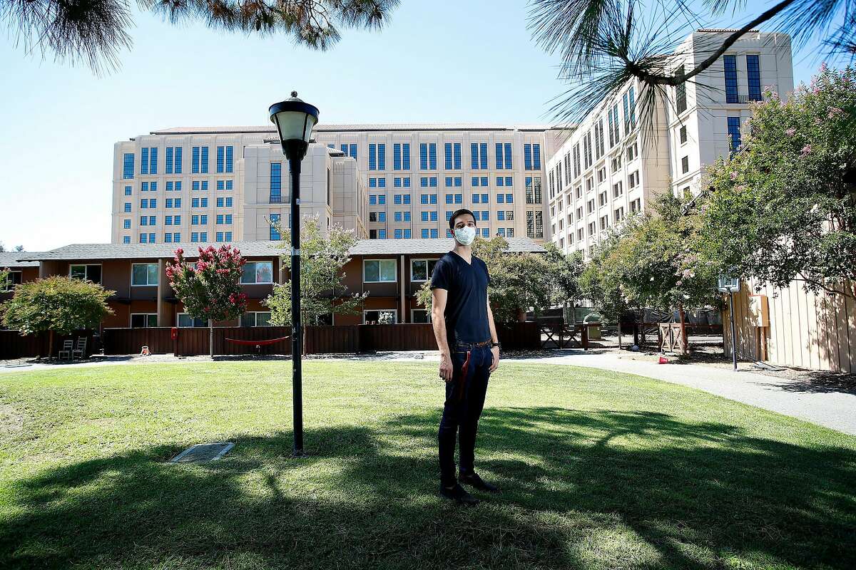 Portrait of Stanford University PHD graduate student Tyler Benster, who is photographed in front of his current housing the brown units and the new tower under construction. At Stanford University, California, on Friday, August 7, 2020.