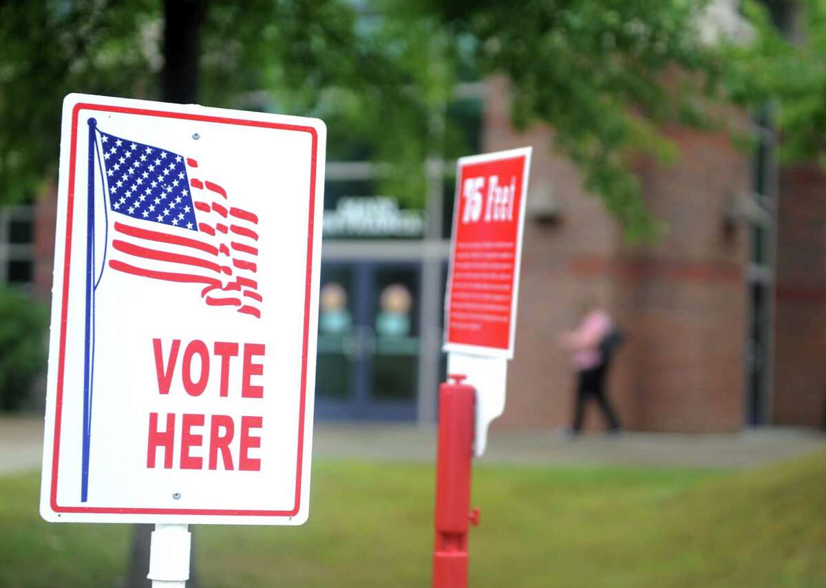 A voter arrives to cast her ballot Tuesday, Aug. 12, 2014 at Shelton Intermediate School in Shelton, Conn.